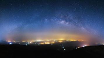 milky way galaxy and city light at Phutabberk Phetchabun in Thailand.Lo photo