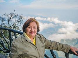 Portrait photo of beautiful asian senior women with beautiful view on Tianmen mountain and clear Sky in zhangjiajie city China.Tianmen mountain the travel destination of Hunan zhangjiajie city China