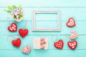 Valentines accessories and vase with flowers on blue wooden table. Top view photo