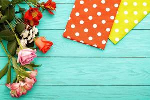 Frame of flowers and towels in polka dots on blue wooden background. Top view and selective focus. Copy space photo