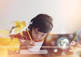 Kid drawing on paper and using tablet research on internet about world population,Ecology or Environmental,School Boy doing online learning,Geography with Double exposure growth leaf on globe map photo