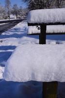 Close-up and detailed shot of benches and a table covered with snow photo
