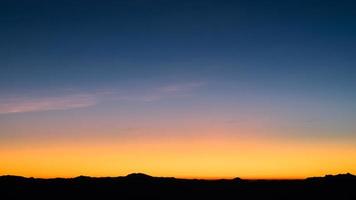 Beautiful bright cloud sky with light for heaven religion background. Sunrise and twilight or sunset cloudscape is orange and blue colours in summer nature. photo