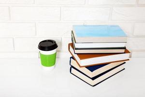 Education literature. Cup of coffee and books on the table in a class. Top view and copy space. Selective focus photo