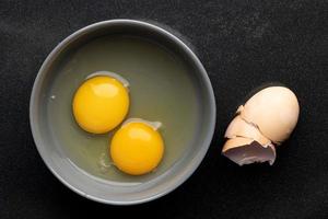 Two raw eggs in a bowl photo