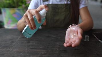 Woman disinfecting hands with alcohol in a spray bottle video