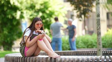 vrouw zittend buiten gebruik makend van telefoon video