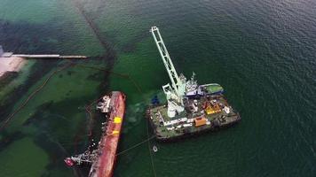 barco de rescate con grúa levantando un barco de carga naufragado en el puerto de odessa video