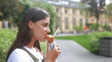 Woman having ice cream cone sitting at square video