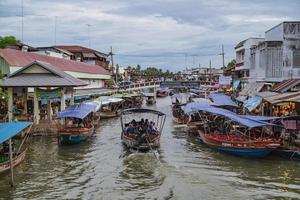 samutsongkhram.thailand - 16 de septiembre de 2017. hermosa vista con turistas desconocidos del mercado flotante de amphawa en tiempo de vacaciones. el mercado de amphawa es un destino de viaje de comida callejera muy famoso en tailandés foto