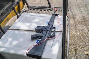 un juguete de pistola negra para niños con la cuerda de plástico atada a la pistola foto