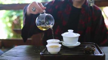 Tea ceremony performed by a young brunette woman on outdoor terrace video