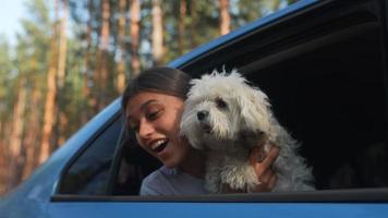 Girl in car holding little cute dog video