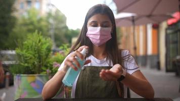 Woman disinfecting hands with alcohol in a spray bottle video