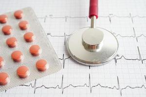 estetoscopio en electrocardiograma con droga, onda cardíaca, ataque cardíaco, informe de cardiograma. foto