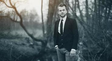 portrait of a young business man in a black suit photo