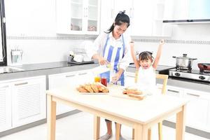 madre e hija toman un desayuno saludable en casa familia feliz en la cocina madre e hija desayunando foto