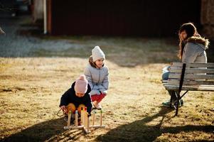 Playing a game throwing ring toss outdoor. Mother with daughters. photo