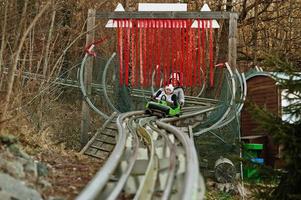 Mother with daughter ride electric sleigh on rails. photo