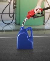 A man fills jerry cans at a gas station photo