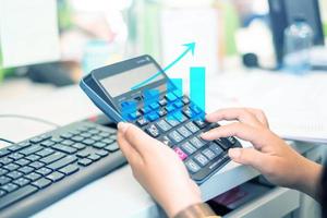 Bank employees are using calculators to serve customers in branches and graphing diagrams. Investment, growth of digital graphs photo