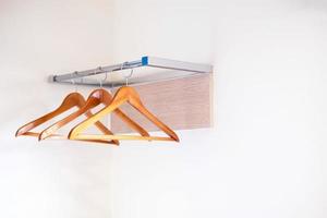 Wooden clothes hangers hanging over a clothesline on a white background, selective focus points photo