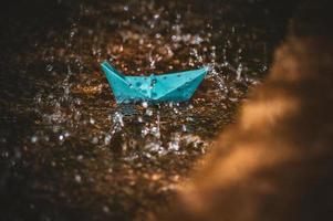 Origami paper boat in the rain photo