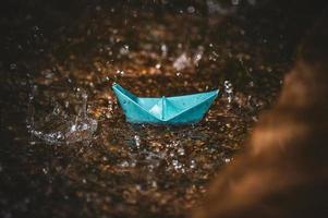 Origami paper boat in the rain photo