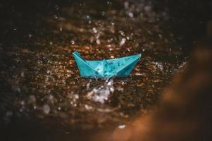 Origami paper boat in the rain photo