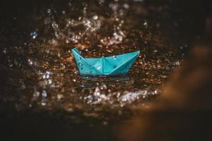 Origami paper boat in the rain photo