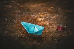 Origami paper boat in the rain photo