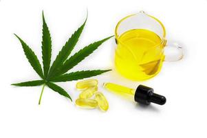 Hemp oil capsules and cannabis leaves on a white background, CBD hemp oil, medical marijuana concept. photo