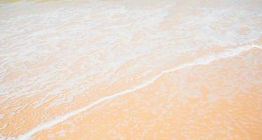 Close-up golden sandy waves water splash shoreline. photo