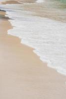 de cerca olas estrellarse desierto arena residuos costa soleado. foto
