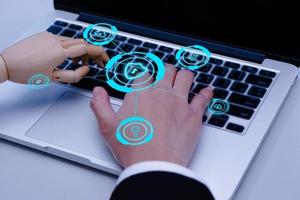 Businessman hand and robot hands show unity with two hands together is working labtop. Concept of Artificial intelligence, technology, join forces, and progress future. photo