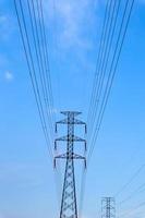 igh voltage electric pole across the land against the blue sky and clouds in Indonesia photo