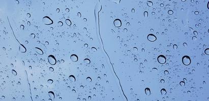 Water droplets perspective through window glass surface against blue sky good for multimedia content photo