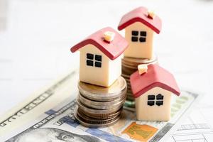 casa con monedas apiladas y dinero en dólares estadounidenses en la casa del plan, concepto de financiación de préstamos hipotecarios.