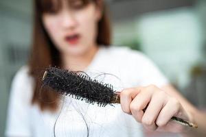 las mujeres asiáticas tienen problemas con la pérdida de cabello largo y se adhieren al cepillo de peine. foto