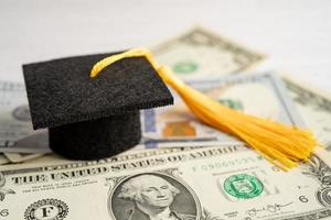 sombrero de la brecha de graduación en el dinero de los billetes en dólares estadounidenses, concepto de enseñanza de aprendizaje de la tarifa de estudio de educación. foto