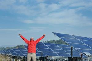 engineer using laptop at solar panels plant field photo