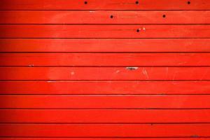 Striped metal textured wall painted in a red, background, abstract horizontal lines, dirty steel colored shutter garage door, grunge texture and pattern. photo