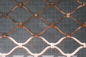 Texture and pattern of a vintage metal net wall, outdoor, old rusty mesh fence, abstract grunge rough grid, retro netting background. photo