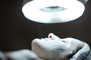 woman with facial mask in cosmetic studio photo