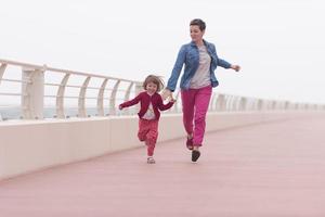 madre y niña linda en el paseo marítimo junto al mar foto