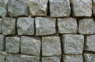 Abstract background of lined wall of granite stones of square shape. photo