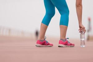 close up on running shoes and bottle of water photo