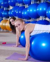 hermosas chicas jóvenes haciendo ejercicio en un gimnasio foto