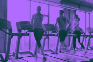 Group of people running on treadmills photo