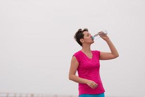 Fitness woman drinking water photo